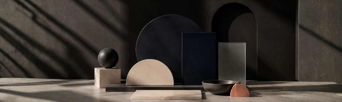 Abstract composition of charcoal, near-black navy and ivory geometric forms with strong shadows.