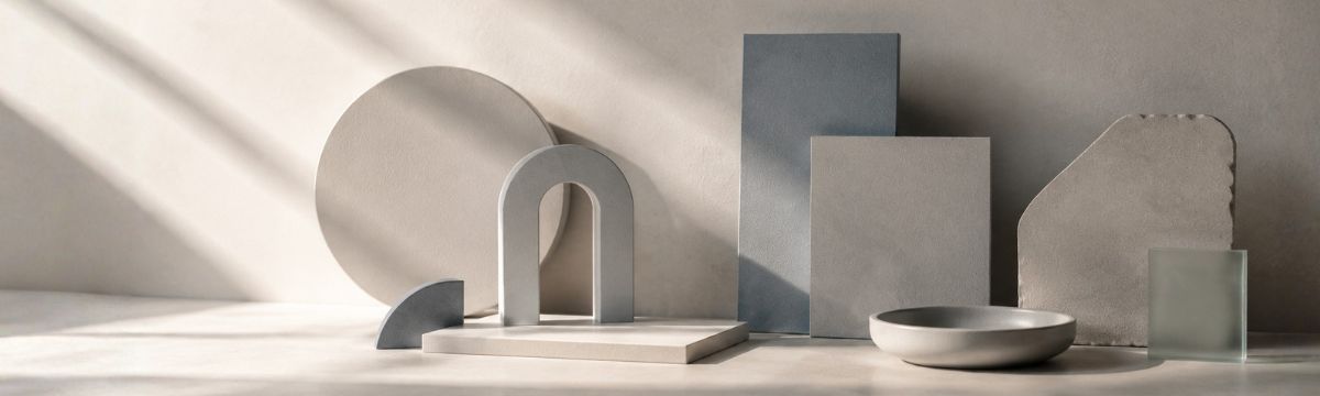 Abstract composition of warm gray, blue-gray and silver geometric forms in soft daylight.