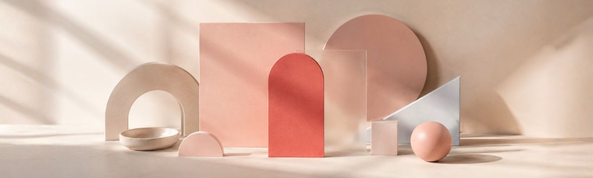 Abstract composition of blush, dusty rose and coral-pink geometric forms in soft daylight.